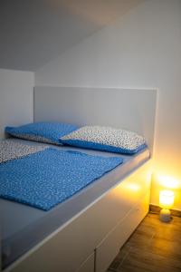 2 Einzelbetten in einem Zimmer mit einer Lampe in der Unterkunft Afrodita in Gornji Karin