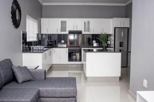 a living room with a couch and a kitchen at CONDO VILLAS ON MARINE DRIVE in Durban
