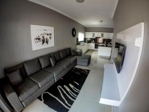 a living room with a couch and a television at CONDO VILLAS ON MARINE DRIVE in Durban