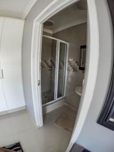a white bathroom with a shower and a toilet at CONDO VILLAS ON MARINE DRIVE in Durban