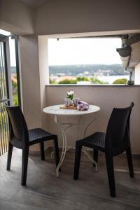 einen Tisch und zwei Stühle in einem Zimmer mit Fenster in der Unterkunft Afrodita in Gornji Karin
