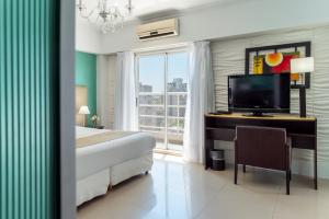 1 dormitorio con 1 cama y escritorio con TV en Ker Urquiza Hotel en Buenos Aires