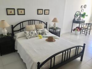 1 dormitorio con 1 cama grande con sombrero en Apartamento Avenida Mar, en Peñíscola