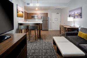 Apartamento con sala de estar con sofá y cocina. en Staybridge Suites - Long Beach Airport, an IHG Hotel en Long Beach