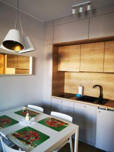 a kitchen with a table with chairs and a sink at Margaret apartament in Świnoujście