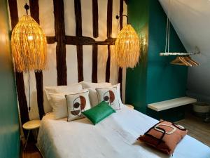 um quarto com uma cama branca com sacos em La maison de Cruso em Sens