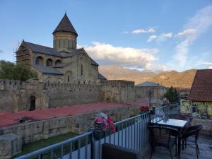 an old building with a clock tower on a balcony at Tamarindi Guest House in Mtskheta