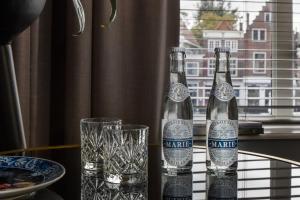two bottles of wine sitting on a table with glasses at Boutique Hotel De Vier Patriciërs in Middelburg