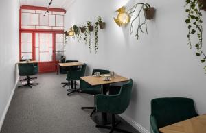 a restaurant with green chairs and tables in a room at Boutique Hotel De Vier Patriciërs in Middelburg