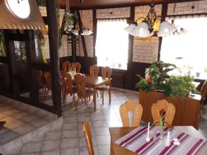 uma sala de jantar com mesas, cadeiras e janelas em Hotel & Restaurant Hildebrandt em Breitenrode
