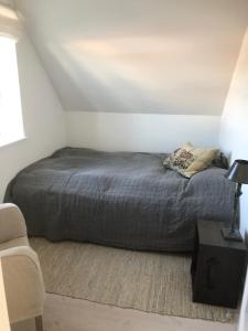 sypialnia z łóżkiem i krzesłem w obiekcie Det gamle badehotel i Grasten w mieście Svendborg