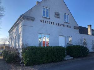 ein weißes Gebäude mit einem Schild an der Seite in der Unterkunft Det gamle badehotel i Grasten in Svendborg