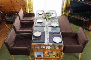 einen Tisch mit 2 Stühlen und einen Tisch mit Tellern und Blumen in der Unterkunft ヴィンテージ那須 in Nasu