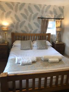 a bed with two pillows and two towels on it at The Jug & Glass Inn in Hartington