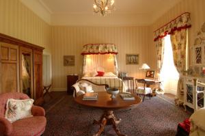 a living room with a bed and a table in a room at Enniscoe House in Crossmolina