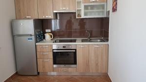 una cucina con lavandino e frigorifero di Ruzica Apartments a Mirce