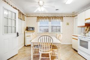 a kitchen with a table and chairs and a ceiling fan at 37534 Lighthouse Rd #202 in Fenwick Island