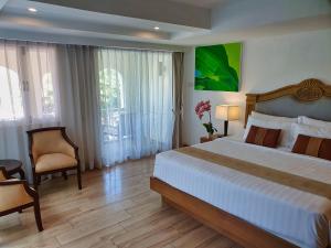 a bedroom with a large bed and a chair in it at Sea Pearl Beach Resort in Patong Beach