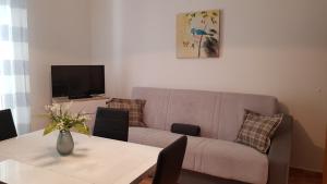 ein Wohnzimmer mit einer Couch und einem Tisch in der Unterkunft Ruzica Apartments in Mirce