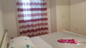 ein Zimmer mit einem Bett mit rosa Blumen darauf in der Unterkunft Ruzica Apartments in Mirce