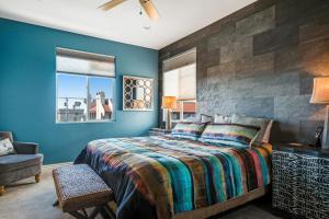 a bedroom with a large bed with blue walls at Coastal Perch in Pismo Beach