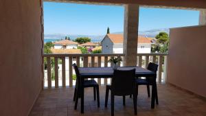 einen schwarzen Tisch und Stühle auf einem Balkon mit Aussicht in der Unterkunft Ruzica Apartments in Mirce