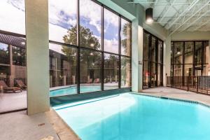 a swimming pool in a building with large windows at Red Roof Inn PLUS & Suites Houston - IAH Airport SW in Houston