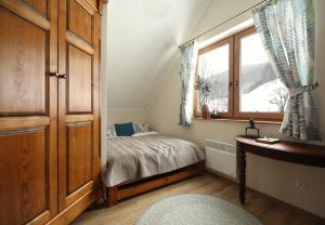 Domek Chmielnik في Pieszyce: غرفة نوم صغيرة بها سرير ونافذة