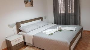 ein Schlafzimmer mit einem Bett mit weißen Handtüchern darauf in der Unterkunft Ruzica Apartments in Mirce