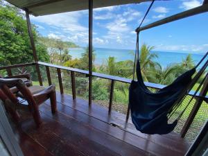 a hammock on a porch with a view of the ocean at Pacheco Tours Beach Cabins in Drake