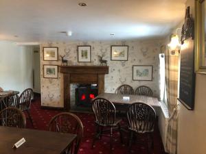 a dining room with a table and chairs and a fireplace at The Jug & Glass Inn in Hartington