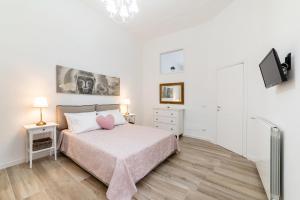 una camera da letto bianca con un letto e una TV di Casa Donna Gina - Puglia Mia Apartments a Monopoli