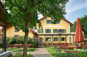 un edificio con mesas, sillas y sombrilla en Gasthaus Zum Himmelreich, en Riedenburg