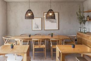 comedor con mesas y sillas de madera en CASA DA ILHA - Slow Living Residence & Suites en Ponta Delgada