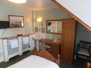 y baño con cama, lavabo y lavabo. en Meadowlea Guest House, en Okehampton