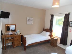 a bedroom with a bed and a desk at Meadowlea Guest House in Okehampton