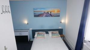 een kleine kamer met een bed met 2 kussens bij Hotel De Wilde Kriek - before De Karsteboom in Valkenburg