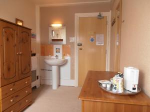 a small bathroom with a sink and a sink at Meadowlea Guest House in Okehampton