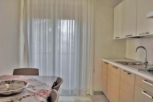 een keuken met een tafel en een raam met gordijnen bij Residence Comfort in Riccione