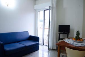 sala de estar con sofá azul y mesa en Residence Comfort, en Riccione
