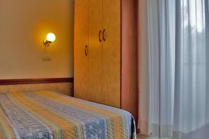 1 dormitorio con 1 cama, armario y ventana en Residence Comfort, en Riccione