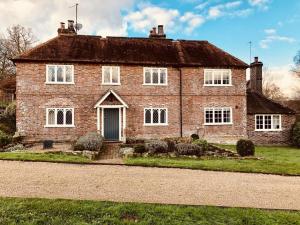 a brick house with white windows and a driveway at The Dorset Arms Pub & Cottage Rooms in Groombridge
