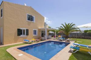 a villa with a swimming pool in front of a house at Villas Nura in Son Carrio