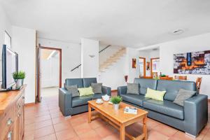 Una sala de estar con dos sofás azules y una mesa. en Villas Nura, en Son Carrio