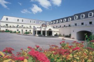 a large white building with a courtyard with flowers at Durrant House Hotel in Bideford