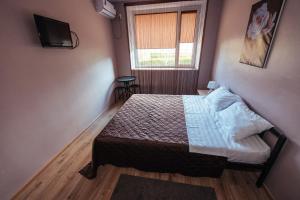 a small bedroom with a bed and a window at Yuzhnyy Bereg Hotel in Yeysk