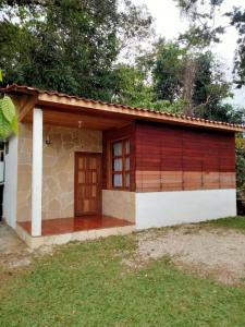 mały dom z brązowymi drzwiami na dziedzińcu w obiekcie Ciudad de Las Rocas w mieście La Fortuna Gallo Giro