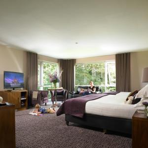 a hotel room with a bed and a woman and a child at Dunboyne Castle Hotel & Spa in Dunboyne