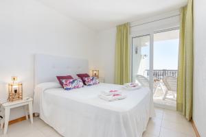 een witte slaapkamer met een bed en een balkon bij Apart-rent Apartament Port Grec 0157 in Empuriabrava