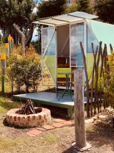 una casita en un jardín con una mesa y un banco en La Estación de Tomine, en Guatavita